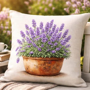 May include: A decorative pillow featuring a watercolor painting of lavender in a terracotta pot. The lavender has vibrant purple flowers and green foliage. The pillow has a neutral background and is placed outdoors.