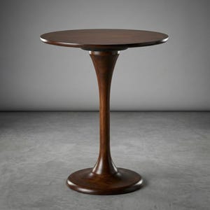 Puede incluir: Una mesa auxiliar redonda de color marrón oscuro con una base de pedestal. La mesa tiene un acabado liso y pulido. La altura de la mesa es de aproximadamente 76 cm.