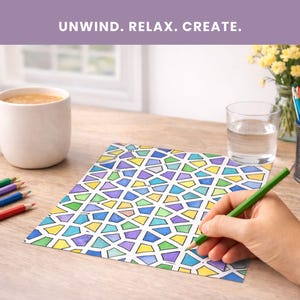 Puede incluir: Una naturaleza muerta con una taza blanca de caf&eacute;, l&aacute;pices de colores y un vaso de agua sobre una mesa de madera. Una mano dibuja sobre un dise&ntilde;o geom&eacute;trico colorido. El texto "UNWIND. RELAX. CREATE." est&aacute; en la parte superior.