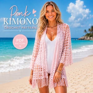 Könnte beinhalten: Ein rosa Kimono-Häkelmuster mit offenem Schnitt und Fransenbesatz. Das Bild zeigt den Text "Pink Kimono Crochet Pattern" und eine "PDF Pattern" Grafik. Der Kimono wird an einem Strand mit blauem Ozean und Himmel im Hintergrund getragen.