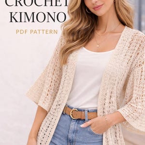 Może przedstawiać: Kremowe kimono z szydełkowym wzorem z otwartym splotem i szerokimi rękawami. Na zdjęciu widoczny jest również brązowy pasek ze złotą klamrą, niebieskie dżinsy oraz napis "BOHO CROCHET KIMONO PDF PATTERN".