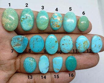 May include: Sixteen oval and rounded turquoise gemstones arranged in three rows. Each stone displays unique natural veining and color variations ranging from pale green to bright sky blue. Each gemstone is labeled with a black number from 1 to 16.
