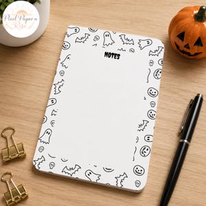 May include: A rectangular notepad with a white background and a black line art border featuring ghosts, bats, skulls, and jack-o'-lanterns. The word NOTES is printed in black at the top center of the page. The notepad is positioned on a wooden surface.