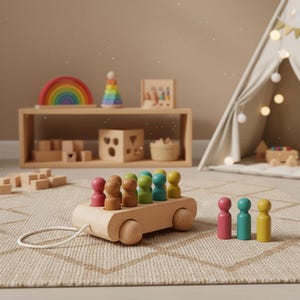 Op de afbeelding: Een houten trekauto met kleurrijke peg-poppetjes. De auto is lichtbruin met een wit trekkoord. De peg-poppetjes zijn in verschillende kleuren, waaronder roze, bruin, groen en blauw. Andere houten speelgoed is zichtbaar op de achtergrond.