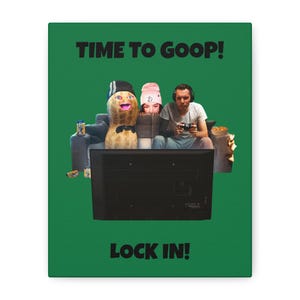 Puede incluir: Impresión en lienzo verde con el texto "TIME TO GOOP!" en la parte superior y "LOCK IN!" en la parte inferior. La imagen presenta un cacahuete de dibujos animados, una persona con un gorro rosa y una persona con auriculares, todos sentados en un sofá frente a un televisor.