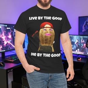 Puede incluir: Camiseta negra con el texto "Live by the Goop, Die by the Goop" en blanco. La camiseta presenta un gráfico de un cacahuete con una cara, usando una gorra roja.