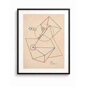 Peut inclure: Impression d'art géométrique abstrait dans un cadre noir. L'œuvre présente un fond beige avec des formes géométriques colorées, notamment des triangles, des carrés et des cercles, reliés par des lignes. Le coin inférieur droit porte le texte "26-1".