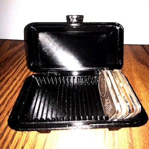 May include: A white ceramic mug with a black handle and the text "But First, Coffee" in a handwritten style. The mug is on a white surface. The mug is approximately 4 inches tall.