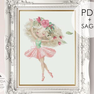 May include: A cross stitch pattern featuring a ballerina with long blonde hair adorned with pink roses, wearing a green bodice and a pink polka-dot tutu. The design is displayed in a white ornate frame with the text PDF + SAGA and MANSARDA cross stitch.