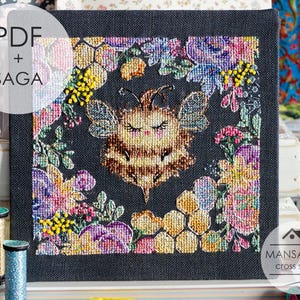 May include: A cross-stitch design of a bee surrounded by flowers and honeycomb on a dark background. The bee has closed eyes and detailed wings. The design is framed by colorful flowers in shades of pink, purple, yellow, and blue. Text in the image reads "PDF + SAGA".