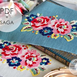 Può includere: Primo piano di due progetti a punto croce con disegni floreali. Uno è su tessuto azzurro chiaro, l'altro su bianco. I fiori sono nei toni del rosso, rosa, blu e giallo. Il testo "PDF + SAGA" è visibile.