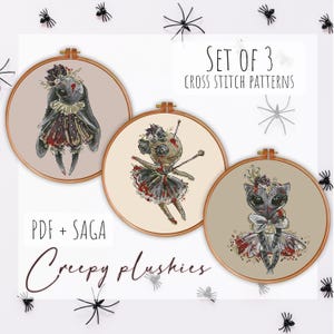 Könnte beinhalten: Ein Set aus drei Kreuzstichmustern in hölzernen Stickrahmen mit illustrierten Plüschfiguren und düsteren, gotisch angehauchten Details. Der Text lautet SET OF 3 CROSS STITCH PATTERNS und PDF + SAGA Creepy plushies. Jeder Rahmen zeigt eine Figur.