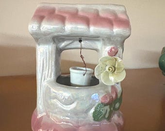 Pozo de los deseos de porcelana estilo Capodimonte, típicamente fabricado en Italia, con un esmalte de acabado brillante sobre un techo rosa vibrante y flores amarillas.