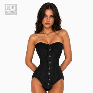 May include: A black strapless corset featuring a vertical row of silver-toned metal busk closures down the center front. The garment is constructed with structured vertical seams and has a curved hemline. The Kilt Outfitters logo is visible.