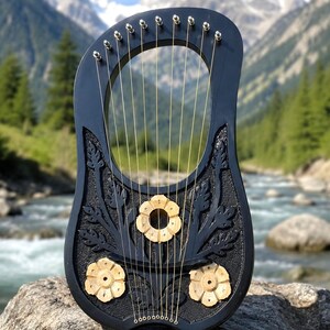 May include: A black wooden lyre featuring ten thin metal strings and three light-colored carved wooden flower accents on the front. The instrument has a smooth, dark frame with intricate leaf-like carvings surrounding the floral elements.