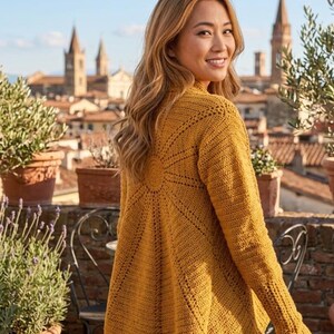 Könnte beinhalten: Eine senfgelbe Strickjacke mit langen Ärmeln und einem kreisförmigen Sonnenstrahlen-Häkelmuster auf der Rückseite. Das Kleidungsstück ist mit einem strukturierten Stich, langen Ärmeln und einem offenen Vorderteil gestaltet.