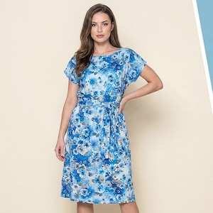 May include: A knee-length dress featuring a vibrant blue and white floral pattern. The garment has short sleeves, a round neckline, and a matching fabric tie belt at the waist that cinches the silhouette. The fabric displays a mix of light and dark blue floral motifs.