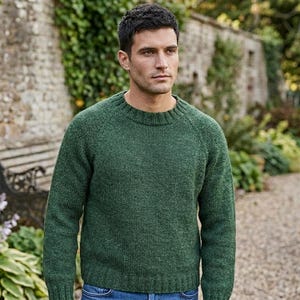Puede incluir: Un suéter de manga larga color verde bosque con cuello redondo clásico y un patrón de punto acanalado en el cuello, los puños y el dobladillo. La prenda está confeccionada con mangas raglán y un tejido de punto texturizado y sólido.