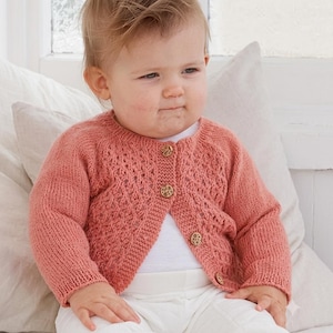 May include: A dusty rose knitted cardigan featuring a textured diamond pattern on the front panels and sleeves, a round neckline, and four small, round, light-coloured wooden buttons down the centre front closure over a plain white shirt.