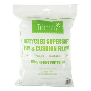 Op de afbeelding: Een doorzichtige plastic zak met Trimits Recycled Supersoft speelgoed- en kussenvulling. De zak heeft een groen label met de merknaam en productinformatie. De tekst op de zak bevat "Safe - Hygienic - Washable - Clear" en "100% Hi-Loft Polyester."
