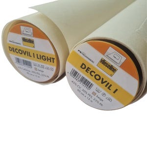 May include: Two rolls of beige Decovil I Light and Decovil I interfacing fabric. Each roll has a label with product information, including the brand Vlieseline, and measurements of 90 cm x 15 m.