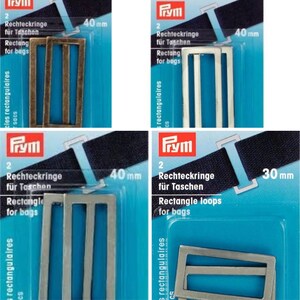 May include: Four packages of rectangular metal loops for bags. The loops are in various colors, including silver, gold, and white. The packages show the size of the loops, with some measuring 40 mm and others 30 mm.