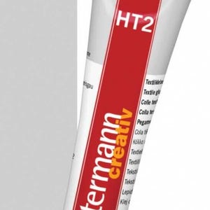 Peut inclure: Tube de colle textile Gütermann HT2, avec un design rouge et blanc. Le tube contient 30g de colle et est étiqueté avec le logo de la marque et des informations sur le produit. On peut lire "Textile glue" et "Colla tessile".