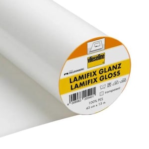 Puede incluir: Un rollo de tela blanca Lamifix Glanz Lamifix Gloss. La etiqueta es naranja y amarilla con el nombre de la marca Vlieseline e información del producto. El rollo mide 45 cm de ancho y 15 m de largo.