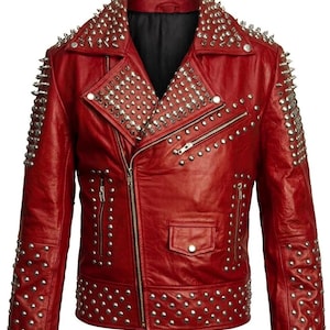May include: A red leather jacket adorned with silver metal studs and spikes. The jacket has an asymmetrical zip, a small pocket, and studded detailing on the shoulders, sleeves, and collar. The interior lining of the jacket is black.