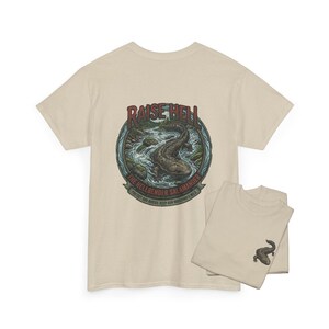 May include: Beige t-shirt with a circular graphic. The graphic includes the text "RAISE HELL" above an illustration of a hellbender salamander in a river. The text "THE HELLBENDER SALAMANDER" and "PROTECT OUR RIVERS, KEEP OUR WATERWAYS WILD" are also included.
