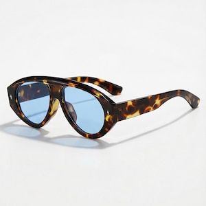 Peut inclure: Une tasse en céramique blanche avec une anse noire et l'inscription "But First, Coffee" en noir, dans une police manuscrite. La tasse est posée sur une surface blanche.