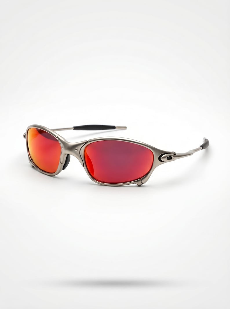 K&ouml;nnte beinhalten: Sonnenbrille mit silbernem Rahmen und leuchtend roten Gl&auml;sern. Das schlanke Design verf&uuml;gt &uuml;ber einen geschwungenen Rahmen und schwarze Akzente an den B&uuml;geln. Diese Sonnenbrille bietet einen stilvollen Look f&uuml;r Outdoor-Aktivit&auml;ten.