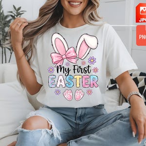 Könnte beinhalten: Weißes T-Shirt mit dem farbenfrohen Schriftzug "My First Easter". Das Design umfasst Hasenohren, eine rosa Schleife, Blumen und Pfotenabdrücke. Das Shirt ist ein lässiger Stil mit kurzen Ärmeln.