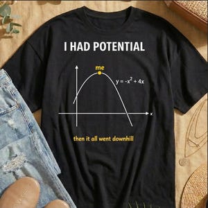May include: Black t-shirt with the text "I HAD POTENTIAL" above a graph. The graph shows a parabola with the text "me" at the vertex and "y = -x² + 4x" next to the curve. Below the graph is the text "then it all went downhill".