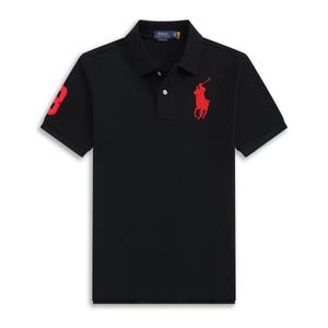 Puede incluir: Polo negro de manga corta. Presenta un número 3 rojo en la manga izquierda y un logotipo de jugador de polo rojo en el pecho. La camisa tiene cuello clásico y cierre de botones.