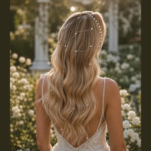 May include: A silver-toned hair chain accessory featuring a delicate grid pattern draped over the back of the head. The fine metal chains are accented with small, round white pearls at each intersection, extending down into long, loose strands.