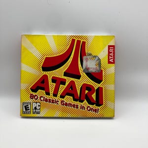 May include: A yellow Atari PC CD-ROM game box with a red Atari logo and text. The box reads "ATARI 80 Classic Games in One!" and has a "PC CD-ROM Software" label.