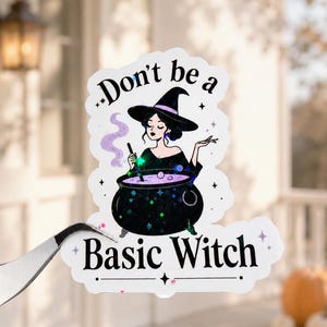 May include: A die-cut sticker featuring a black-haired witch in a pointed hat stirring a purple potion in a black cauldron. The design includes the text "Don't be a Basic Witch" in black lettering, accented with holographic star details.