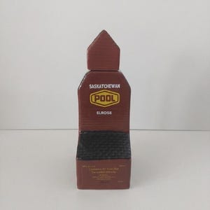 May include: A brown rectangular bottle of Saskatchewan Pool Elrose Canadian Whisky. The bottle has a dark brown cap and a label with the text "Saskatchewan Pool" and "Elrose". The bottle contains 120ml of 10-year-old Canadian Whisky.