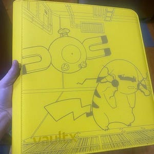 May include: A bright yellow binder featuring a dark grey line art illustration of a Magnemite and a Pikachu character. The cover includes a detailed background design of a room and the word vaultx printed in the bottom left corner of the front.