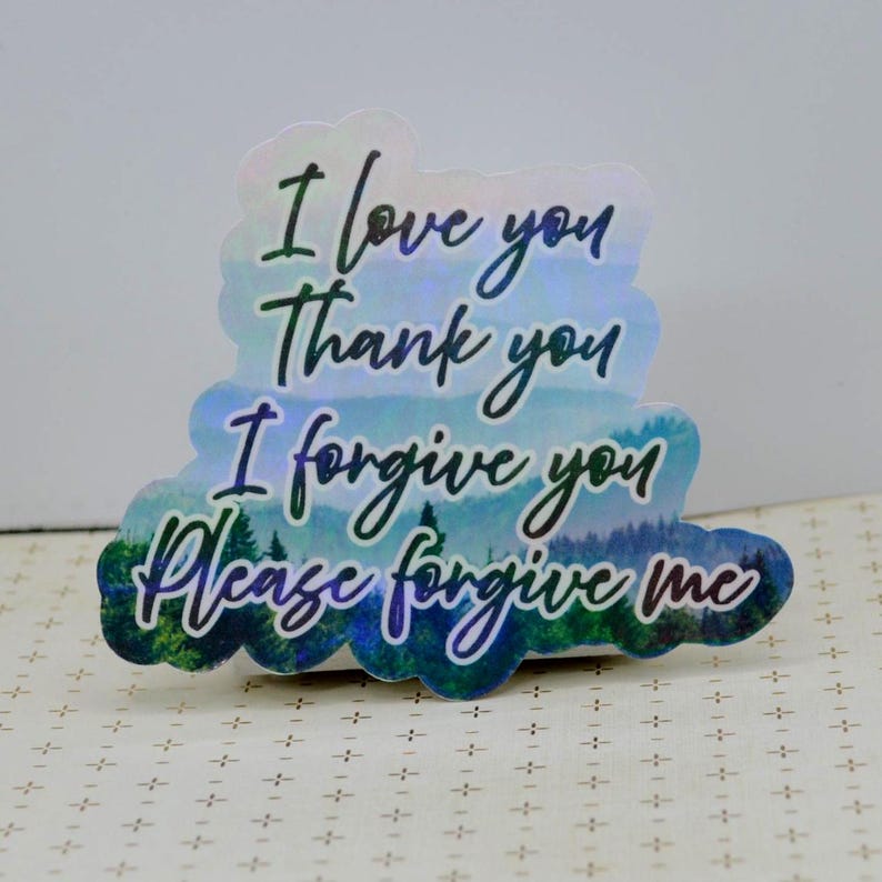 May include: Holographic sticker with the phrases "I love you", "Thank you", "I forgive you", and "Please forgive me" in black script. The sticker has a blue and green landscape design at the bottom.