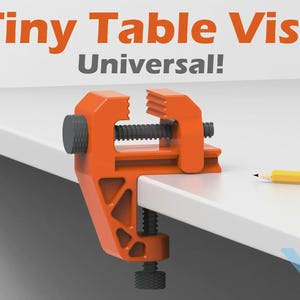 May include: An orange Tiny Table Vise clamps onto a white surface. The vise has a black screw and handle. A yellow pencil rests on the surface. The text "Tiny Table Vise Universal!" is displayed in orange and gray.