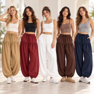May include: Five sets of matching outfits, each consisting of a sleeveless tank top and high-waisted, loose-fitting pants with a drawstring waist and elasticized cuffs. The colors include beige, burgundy, white, brown, and navy blue.