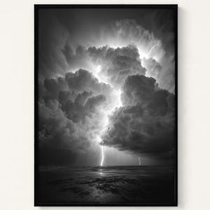 May include: Black and white framed print of a dramatic thunderstorm over a body of water. The image captures a bright lightning strike illuminating the dark, ominous clouds and the water's surface. The artwork is a striking depiction of nature's power.