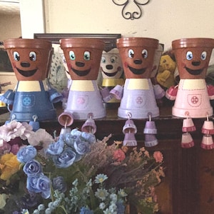 Personas en macetas de terracota pintadas a mano. Decoración de jardín original. Diseños personalizables de mariposas, mariquitas y perros.