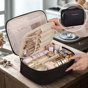 May include: A black rectangular cosmetic travel case with a zip closure. The interior features a mesh zipped pocket, a flap with elastic loops for makeup brushes, and a main compartment with adjustable dividers holding various skincare bottles.