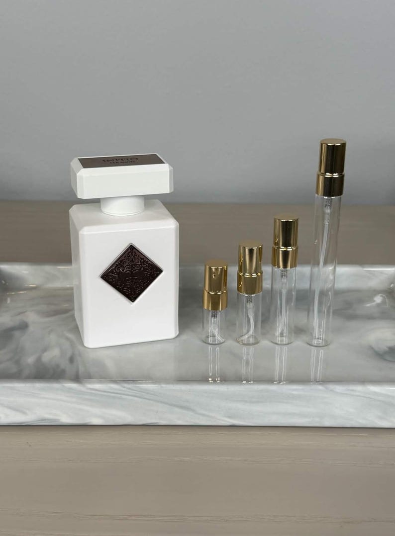 Op de afbeelding: Een set van drie keramische mokken met een gespikkelde, cr&egrave;mekleurige glazuur. Elke mok heeft een ander handgeschilderd ontwerp: een blauw en groen blad, een gele bloem en een rode bes. De mokken hebben een eenvoudige, afgeronde vorm.