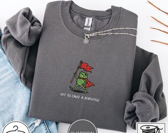 Sudadera Gildan 18000 bordada con la frase "Off To Cause A Kerfuffle" (Disfruta de la emoción) Camiseta divertida de scooter con estampado de rana y animales graciosos. Humor adulto sarcástico sobre salud mental.