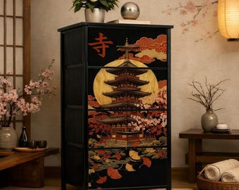 Puede incluir: Una cómoda negra con un panel frontal de varios cajones decorado con una gran luna dorada, una pagoda de varios niveles, flores de cerezo rojas y hojas de ginkgo. El carácter kanji japonés para templo está impreso en rojo arriba a la izquierda.