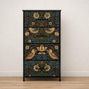 May include: A tall, four-drawer chest of drawers featuring a black metal frame and a dark, intricate botanical pattern on the drawer fronts. The design displays stylized birds, large cream-colored flowers, and green foliage on a dark blue background.